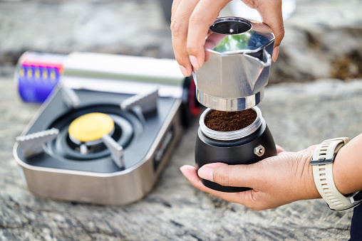 Closeup woman is making a coffee with a Moka pot