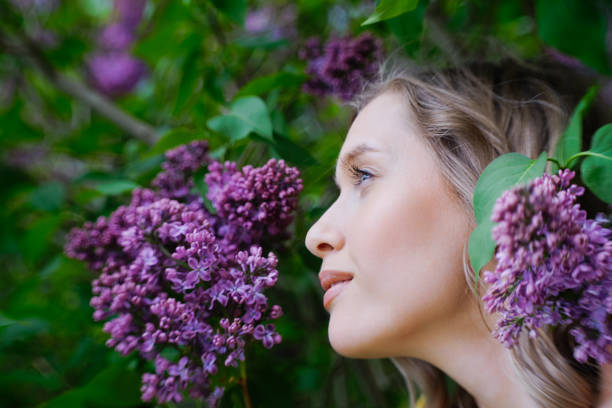 beautiful blonde woman near lilac blossoms close up portrait
