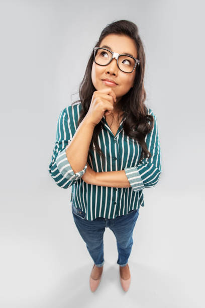 istock asian woman in glasses looking up and thinking 1402130834