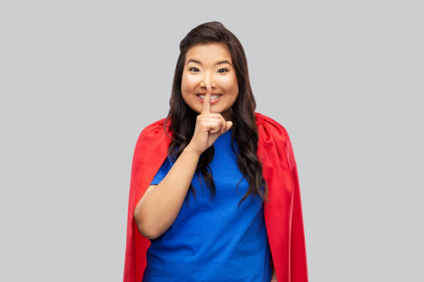 istock asian woman in superhero cape making hush gesture 1402131040