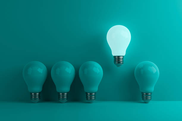 istock Glowing LED light bulb among non-luminous bulbs on a turquoise background. 1402132368