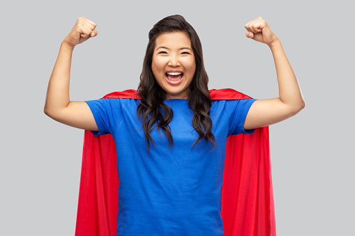 happy asian woman in red superhero cape