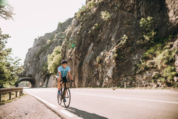 road cycling in the country Man Riding Bicycle On Road upward mobility stock pictures, royalty-free photos & images