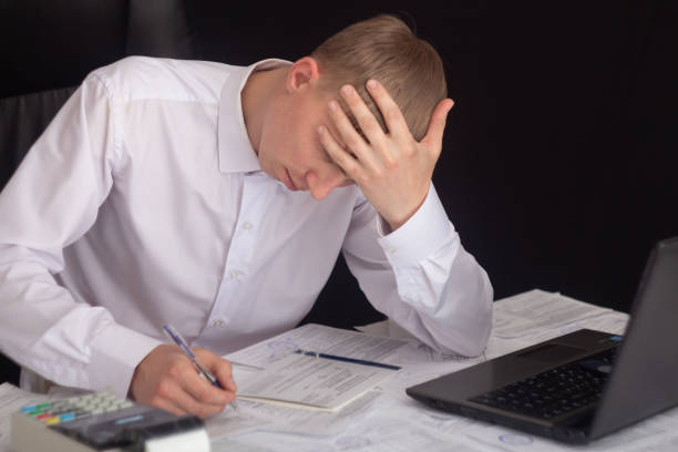 istock A businessman works with stocks, bonds, obligations, securities and documents in a night office. Fulfillment of obligations to work with documents in the office. Employee at a laptop in the office. 1402134802