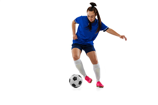 Leg kick. One sportive girl, female soccer, football player training isolated on white studio background. Concept of sport, fitness, women in sports. Young sportive girl in motion. Copy space for ad