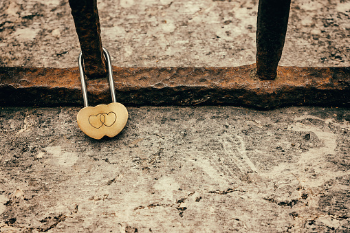 Wedding lock in soft focus as a symbol of love, tenderness, romance, eternity and endless love for lovers. Padlocks are attached to the railings of the bridge. Kuldiga, Latvia.