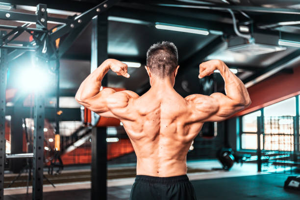 istock Handsome power bodybuilder showing his back at the gym 1402140225