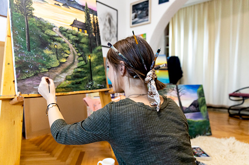 Young painter creates in her studio at home