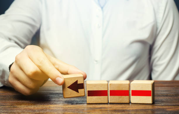 istock Man builds an red arrow from blocks. Business development, growth process concept. Progress and movement forward. Career promotion, improving skills. Business building and expansion. Goal achievement. 1402141362