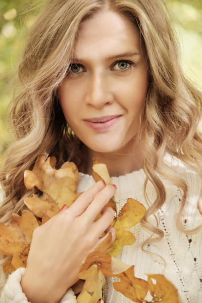 happy autumn woman posing in sunny park, looking at camera
