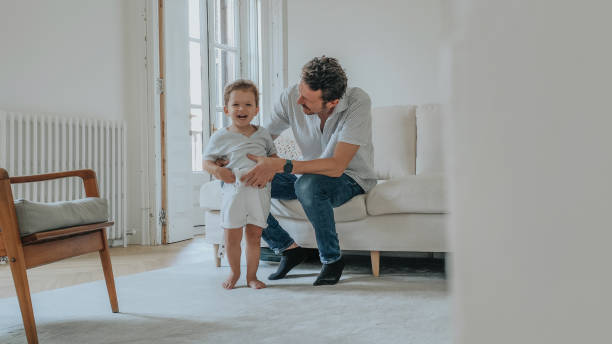 istock Father changing son's clothes at home 1402145099