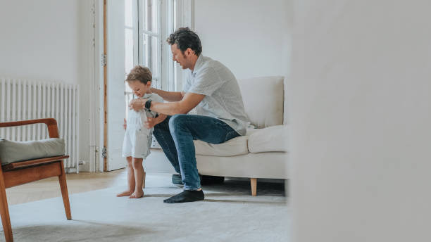 istock Father changing son's clothes at home 1402145109