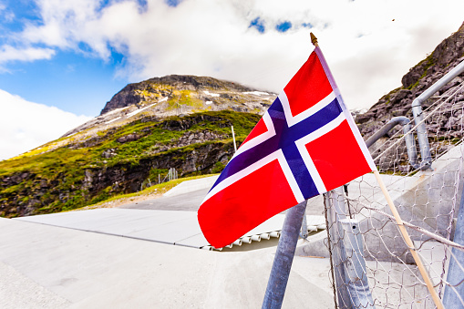 Norwegian flag against Utsikten viewpoint at Gaularfjellet. Tourist attraction. Scenic route in Norway.