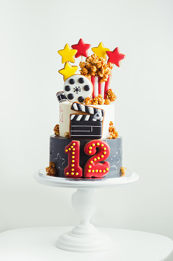 Bunk cake with gingerbread cookies in the shape of cinema camera and popcorn. Cake for a movie star, operator or film director