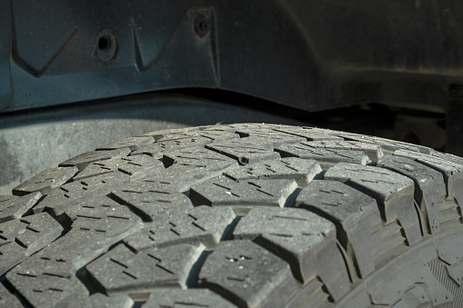 Close-up of a car tire with a large tread.