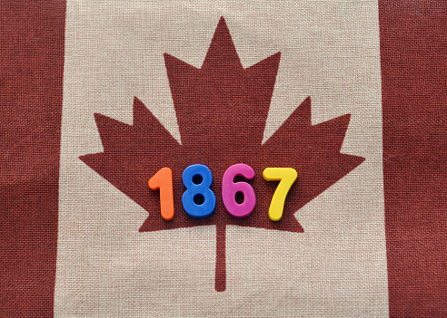 Closeup of a Canadian Flag with numbers reading 1867 on it, symbolizing Canada's birthday.
