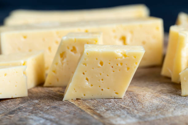 sliced natural cow's milk cheese, fresh yellow milk cheese on a board