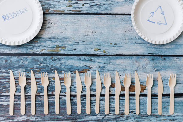 istock Flat lay composition with eco-friendly tableware on light blue wooden background. Kraft paper plates and wooden cutlery. Recyclable paperware, zero waste concept. Selective focus 1402159551