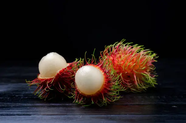 Fresh and ripe rambutan fruit with a sweet taste on black background.
