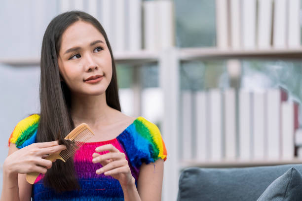 mois de la fierté. femme se peignant les cheveux sur le canapé. femme brossant et démêlant les cheveux longs d’elle. - the splits photos et images de collection