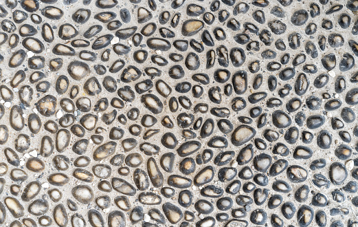 Pebble pavement background. Full frame of smooth pebbles, natural stone textured background