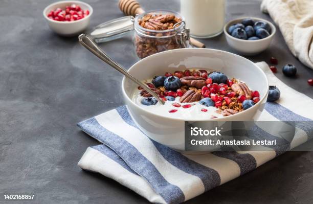 Granola Muesli With Pomegranate Seeds Blueberries And Yogurt Stock Photo - Download Image Now