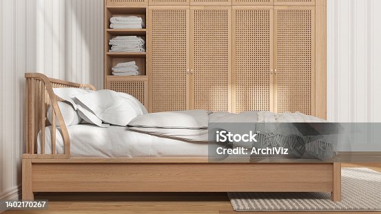 istock Scandinavian wooden bedroom in white and beige tones, double bed with pillows, duvet and blanket, striped wallpaper, rattan wardrobe, parquet floor. Side view, modern interior design 1402170267