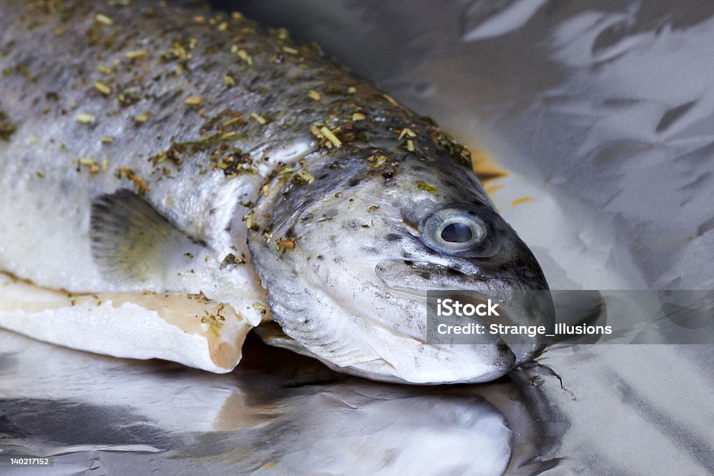 rainbow trout A rainbow trout with herbs on aluminum foil. Fish Stock Photo