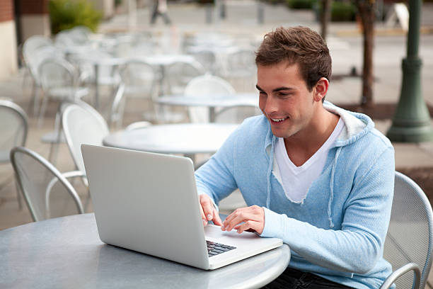 istock Young man smiles with laptop 140217200