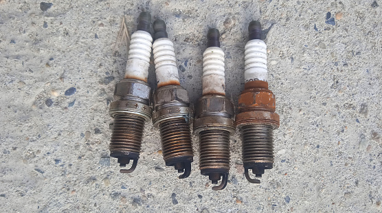 Used car spark plugs. 4 pieces. Black tips. Car repair. Replacement of consumables. Tech service. Rust. Modern detail.