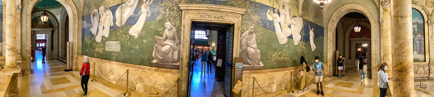 Boston, Massachusetts, USA - May 18, 2022: Panoramic view of the Grand Staircase and the Puvis de Chavannes Gallery at The Boston Public Library. Encircling the main staircase are eight panels representing disciplines that one could pursue in the library. The Boston Public Library contains approximately 24 million items, making it the third-largest public library in the United States behind the federal Library of Congress and the New York Public Library.