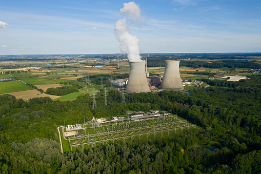 Aerial view of power plant, a large high voltage transformer station and power lines.