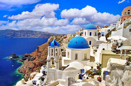 Iconic view with blue domes and caldera of most beautiful island  - Santorini,  Oia village, Cyclades . Greece