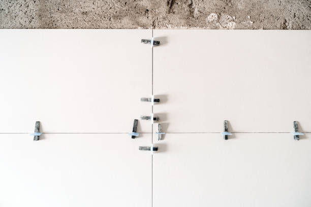 istock construction site. white modern tiles on bathroom with separator and leveling during works. Home renovation 1402187152