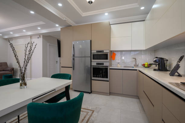 istock Modern white and beige large luxurious kitchen and dining table in studio apartment 1402189253