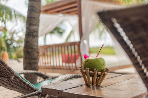 Green coconut on a table at the beach - concept