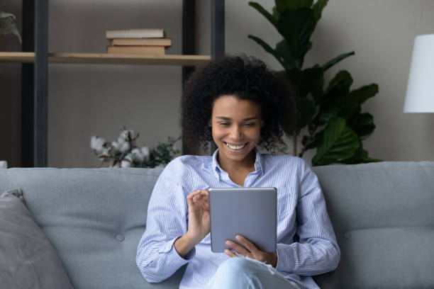 istock Happy beautiful young African American using tablet at home. 1402192400