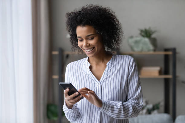 istock Smiling young African woman using smartphone applications. 1402192451