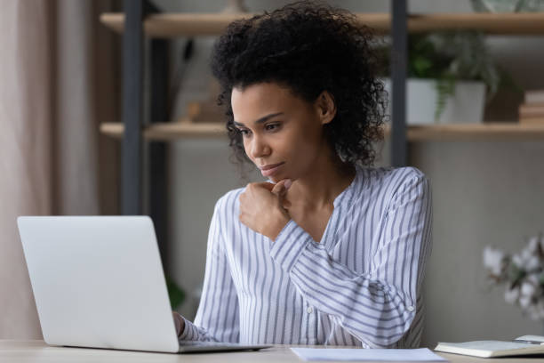 istock Thoughtful young African ethnicity business lady working on computer. 1402192463