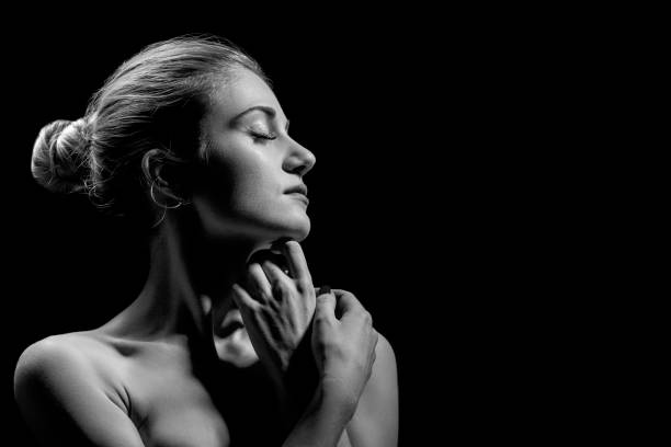 istock beautiful female profile with bare shoulders on black background with copy space, monochrome 1402193380