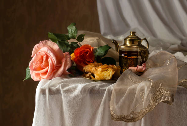 Still-life with spring roses and coffee service on a wooden table close-up