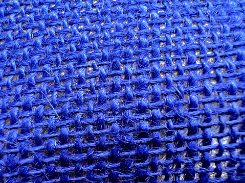 A macro image of a blue braided fabric as a texture or background.