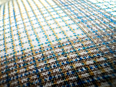 A fine and checkered fabric with different colors as a texture or background.