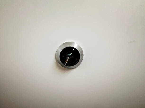 istock A peephole in a white door. 1402197225