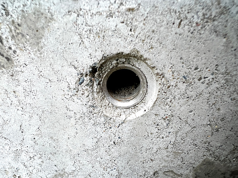 A hole with an iron thread in a very fine white concrete.