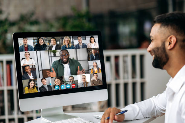 Online conversation by video conference. Successful Indian business man has a virtual meeting with multiracial business colleagues, discussing financial strategy, talking on a video call,brainstorming stock photo