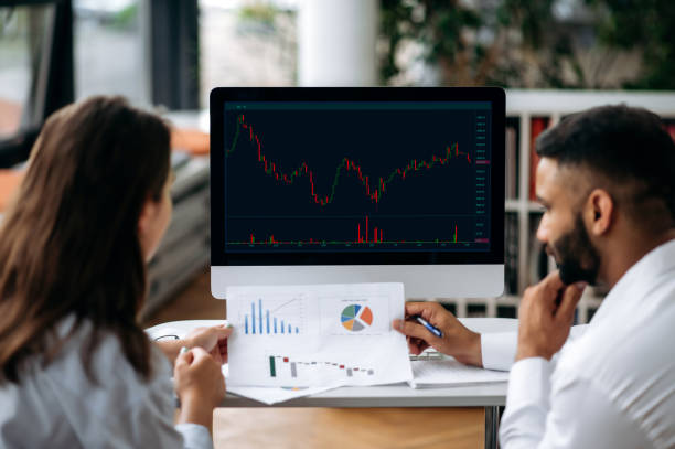 istock Smart successful business colleagues in trading, sitting in modern office, looking at screen with stock market graphs, analyzing dynamics, developing a strategy, discussing prospects and opportunities 1402198723