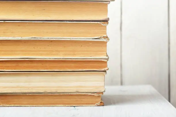 Stack of old books on wooden shelf