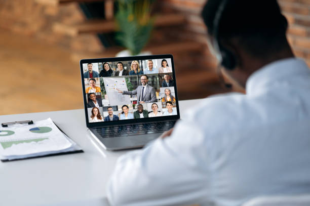 istock Business briefing. Black guy looking at laptop screen, talking on video call with multinational business group, holds conference, virtual meeting, brainstorming with colleagues online,improving skills 1402204486