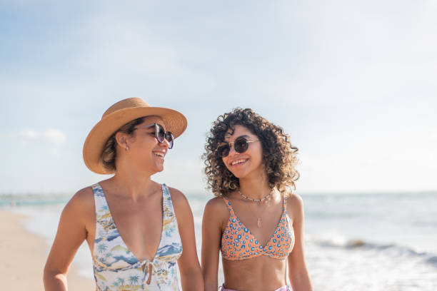 istock Mother and daughter walking along the beach 1402204537